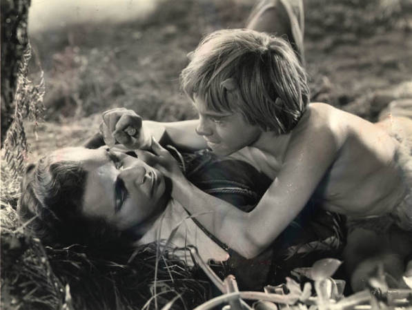 Puck (Mickey Rooney) squeezes the juice of a charmed flower into Lysander's eyes (Dick Powell) (Max Reinhardt, 1935)